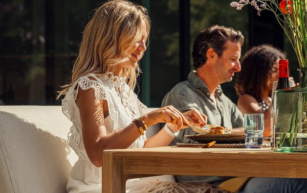 Mensen eten aan de Gescova Grace Low dining set in de zon